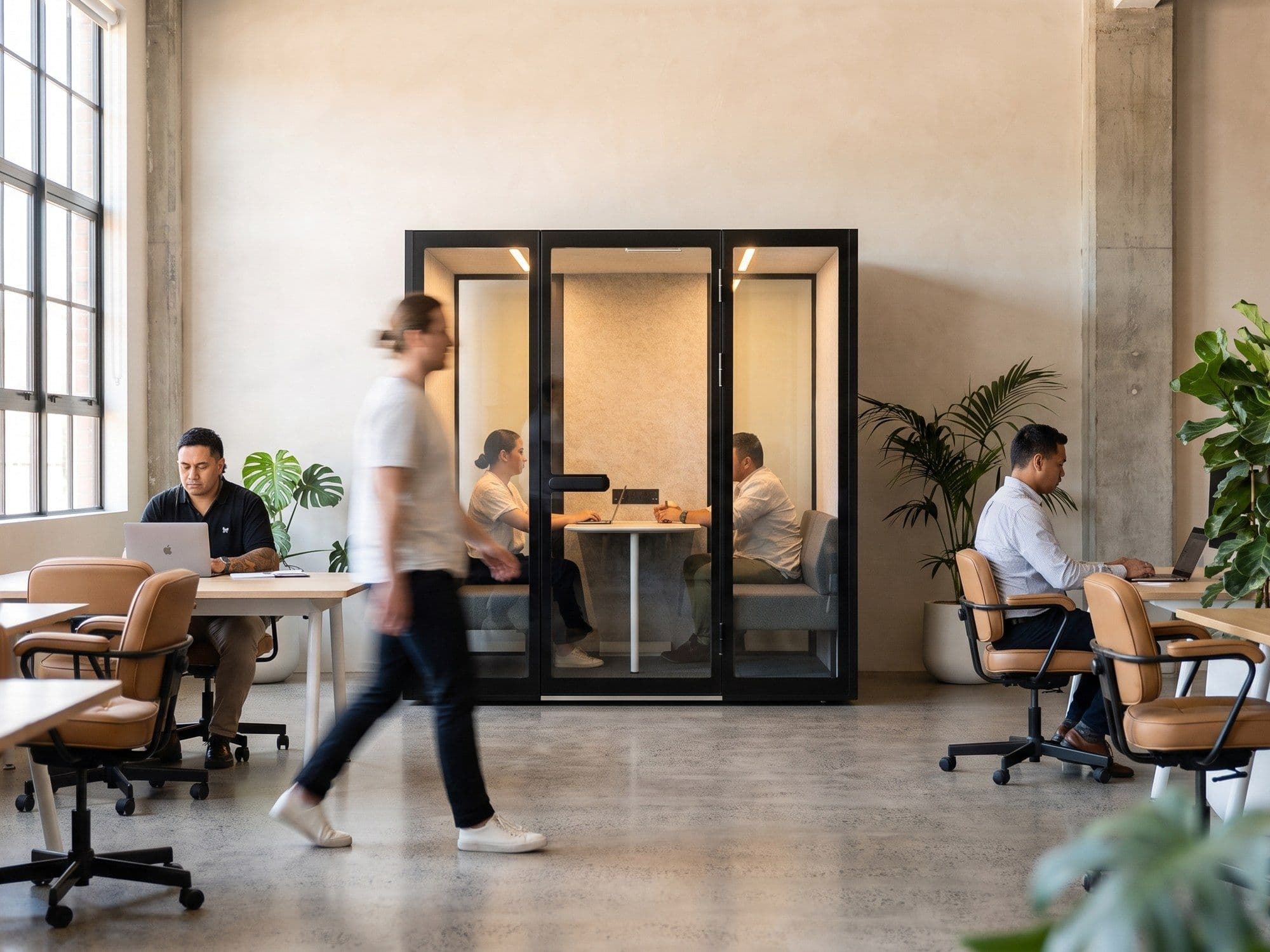 A Peacepod meeting pod in a brick-walled loft office