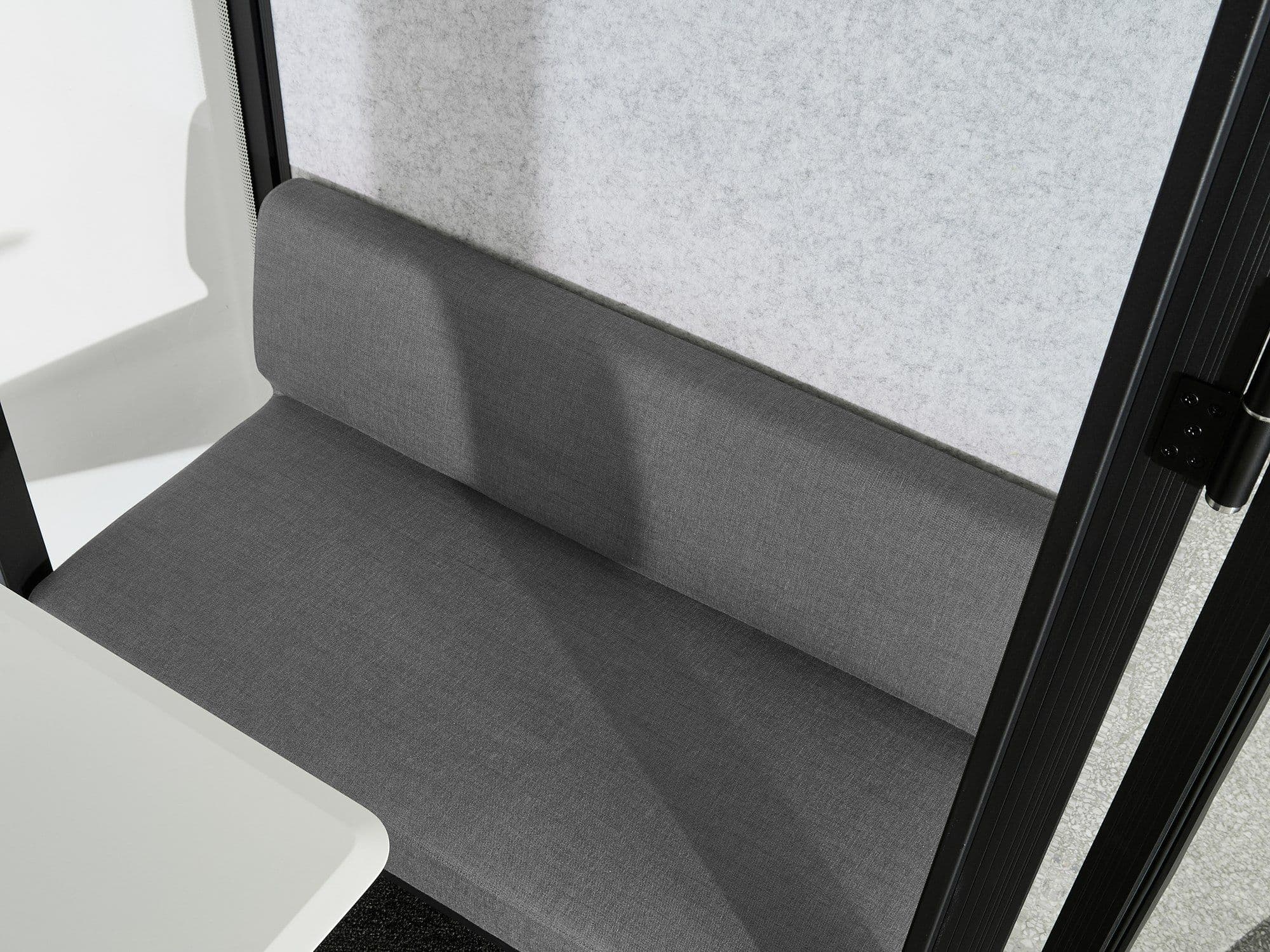 The grey upholstered sofas inside an L4-Pod