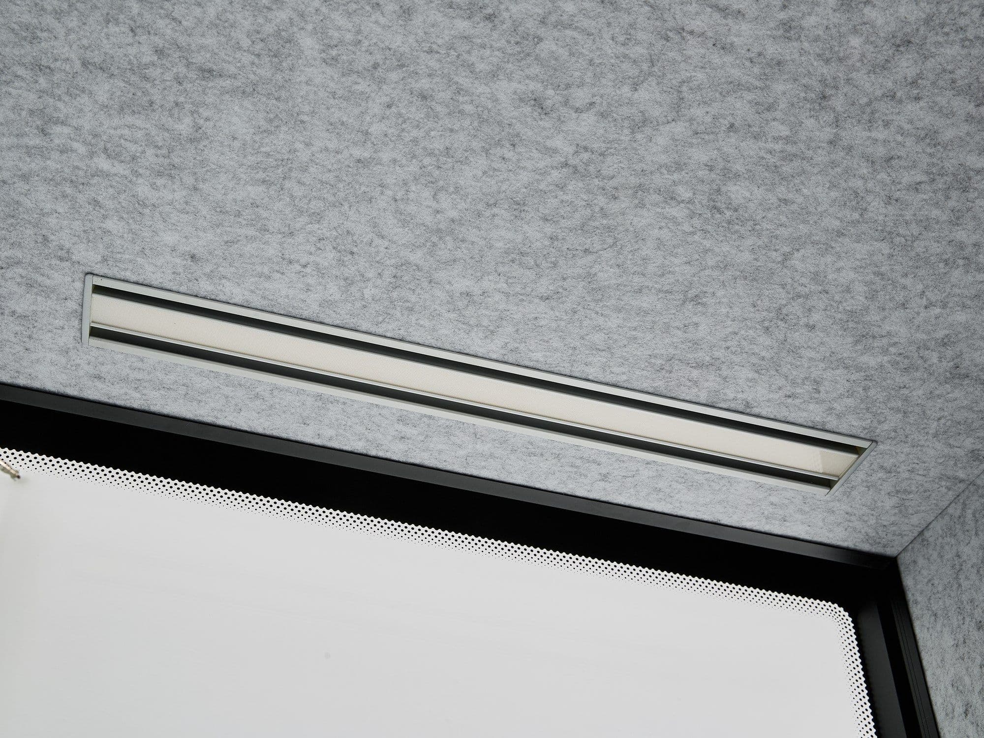 The recessed LED strip light running along the top edge of a Peacepod interior, above the white desk