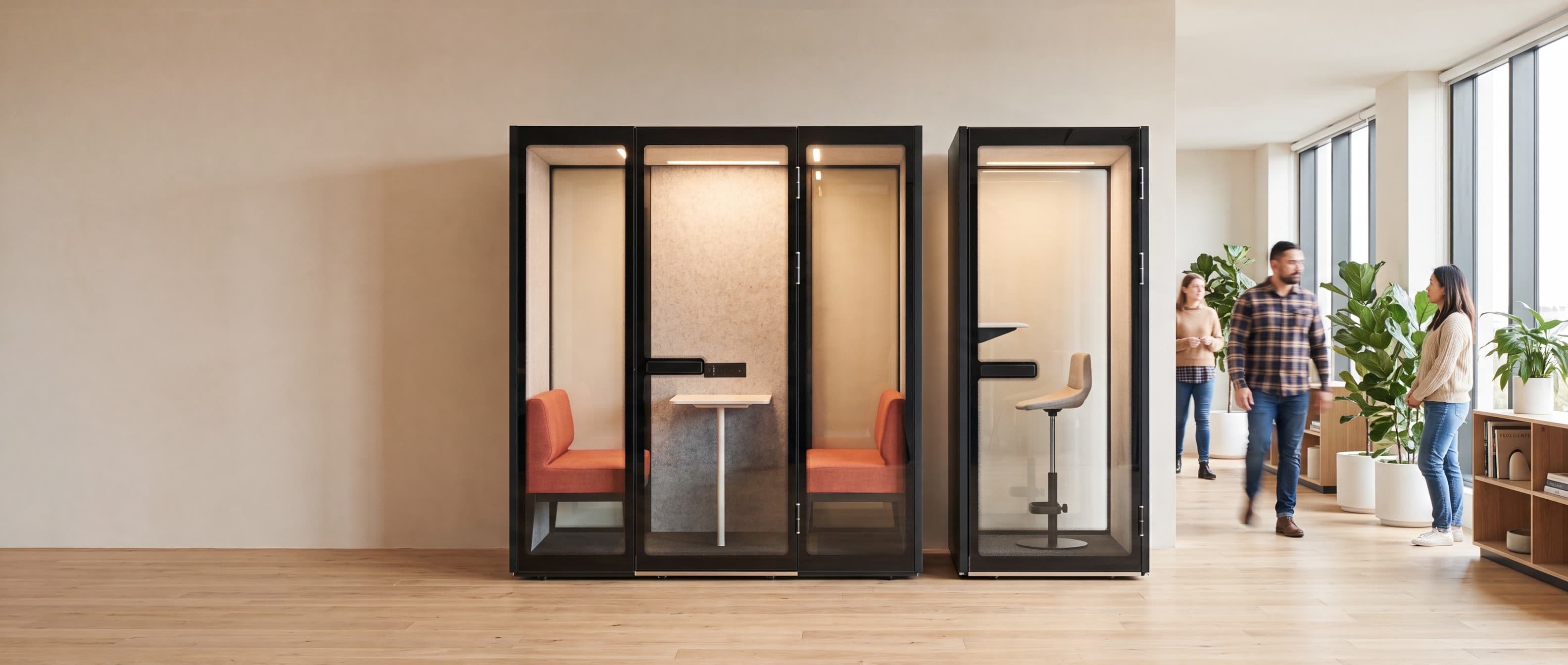 A Peacepod meeting pod and phone booth installed side by side in a bright open-plan office, with colleagues walking past